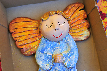 Image showing Little wooden painted angel figure sleeping in box