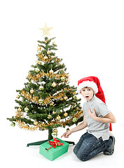 Image showing happy boy in santa hat surprised by christmas present