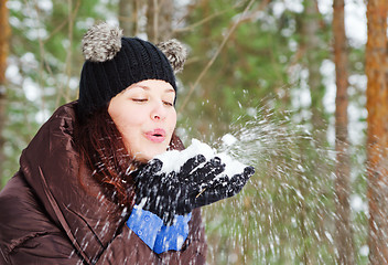Image showing Cute young woman playing with snow  outdoors