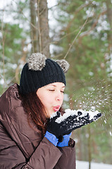 Image showing Cute young woman playing with snow  outdoors