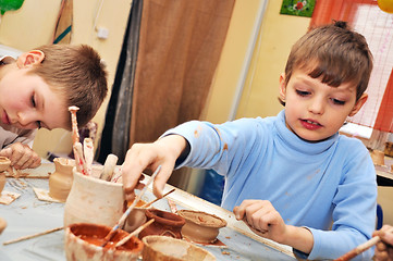 Image showing children shaping clay in pottery studio