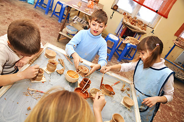 Image showing 	group of children shaping clay in pottery studio