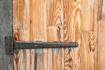 Image showing Detail of wooden door with a metal hinge