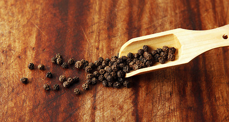 Image showing Pepper grains and wooden spoon 