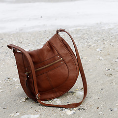 Image showing Brown purse on sand 