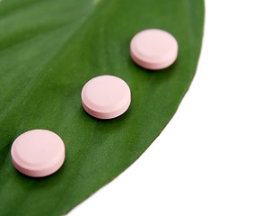 Image showing Natural pills and a green leaf 