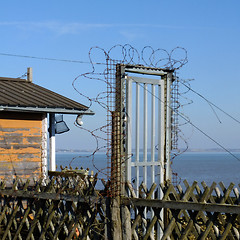 Image showing Barbed wire around a closed gate.