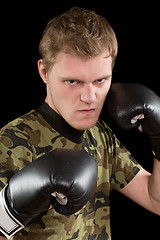 Image showing angry young man in boxing gloves