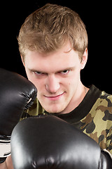 Image showing grinning young man in boxing gloves