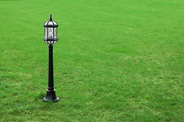 Image showing Metal black street lamp on green grass