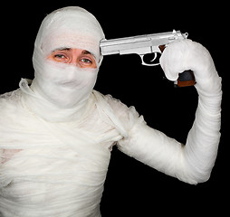 Image showing Completely bandaged man with gun - suicide