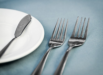 Image showing Served restaurant table with forks, white plate and knife