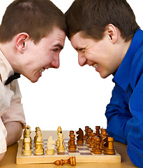 Image showing Two aggressive chess opponents under chess board