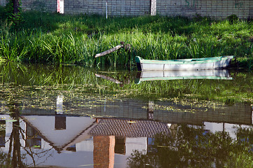 Image showing boat moored river shore house reflections water 