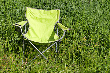 Image showing Green folding chair on the grass