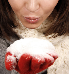 Image showing Young woman blowing snow