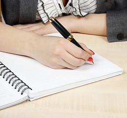 Image showing Businesswoman writing in her agenda