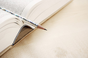 Image showing Open book and a pen