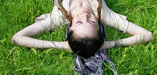 Image showing Young female lying on the grass