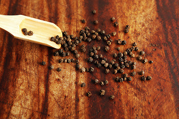 Image showing Pepper grains and wooden spoon