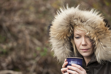 Image showing Blonde Woman with Beautiful Blue Eyes Drinking Coffee