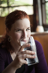 Image showing Young Woman with Beautiful Auburn Hair Drinking Water