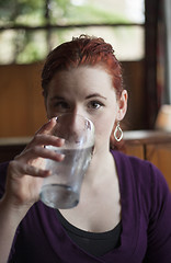 Image showing Young Woman with Beautiful Auburn Hair Drinking Water