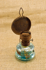 Image showing rusty retro kerosene lamp burlap background 