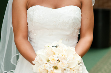 Image showing Bride holding bouquet with wedding rings.