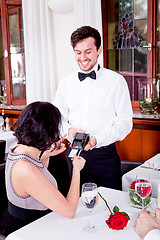 Image showing dinner in restaurant man and woman pay by credit card