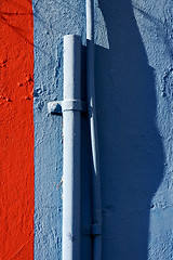 Image showing blue colored pipe and red wall 