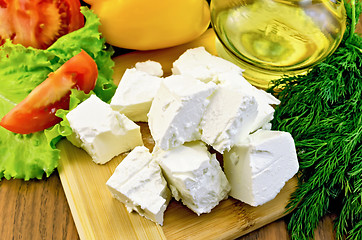 Image showing Feta cheese on the board with vegetables and oil