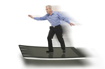 Image showing Senior businessman keeping balance on a PC tablet