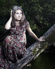 Image showing Beautiful girl in floral dress stand in garden.