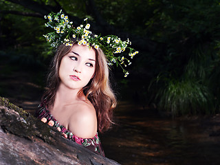 Image showing Beautiful girl in national dress and wreath stand in the forest 