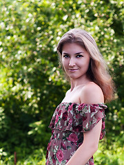 Image showing Beautiful girl in floral dress stand in garden.