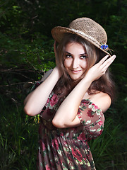 Image showing Beautiful girl in the national dress and hat stand in the  fores