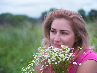 Image showing Portrait of young woman with bouquet of daisies.
