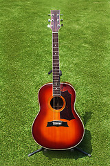 Image showing Acoustic guitar on background of green grass.