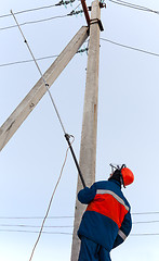 Image showing Electrician to install a protective ground connection to the pow