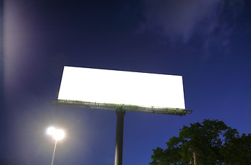 Image showing Blank billboard in a blue sky and green tree as a background