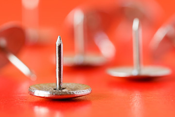 Image showing drawing pins on red background