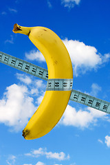 Image showing banana with measure tape on sky background
