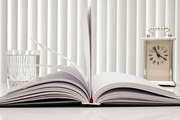 Image showing book,clock and glass of water