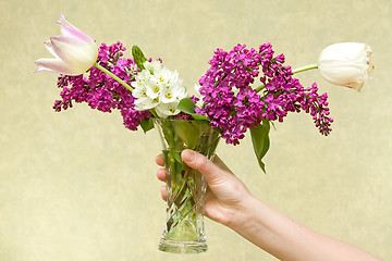 Image showing hand holding vase with various flowers