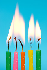 Image showing birthday candles burn on blue background