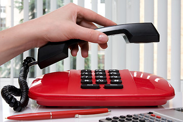 Image showing  hand picking up the handset of telephone