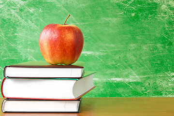 Image showing books with apple against dirty chalkboard