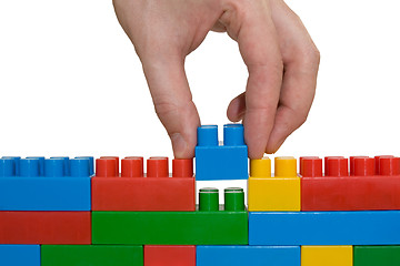 Image showing hand building up lego wall