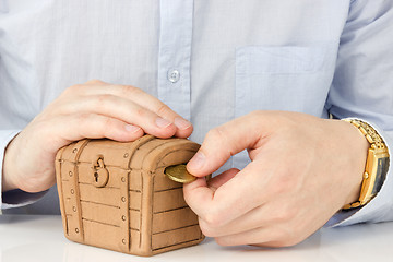 Image showing hand putting coin into a money-box